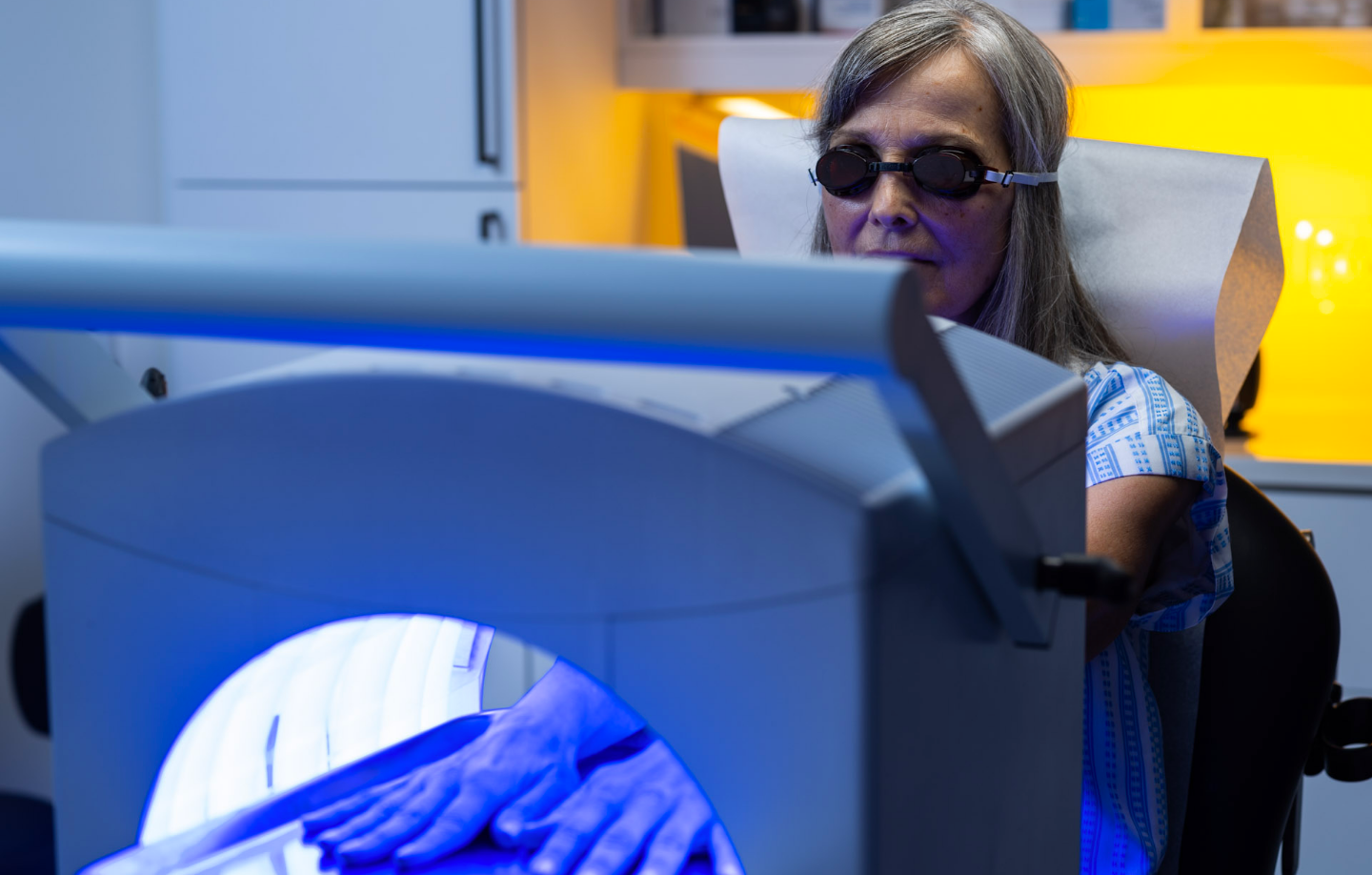 Photo of woman under blue light wearing goggles